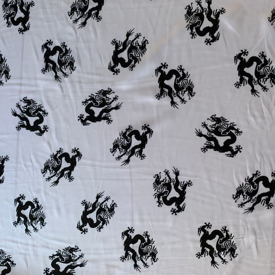 White satin fabric with black dragons
