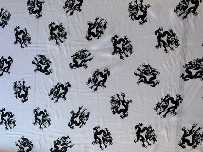 White satin fabric with black dragons